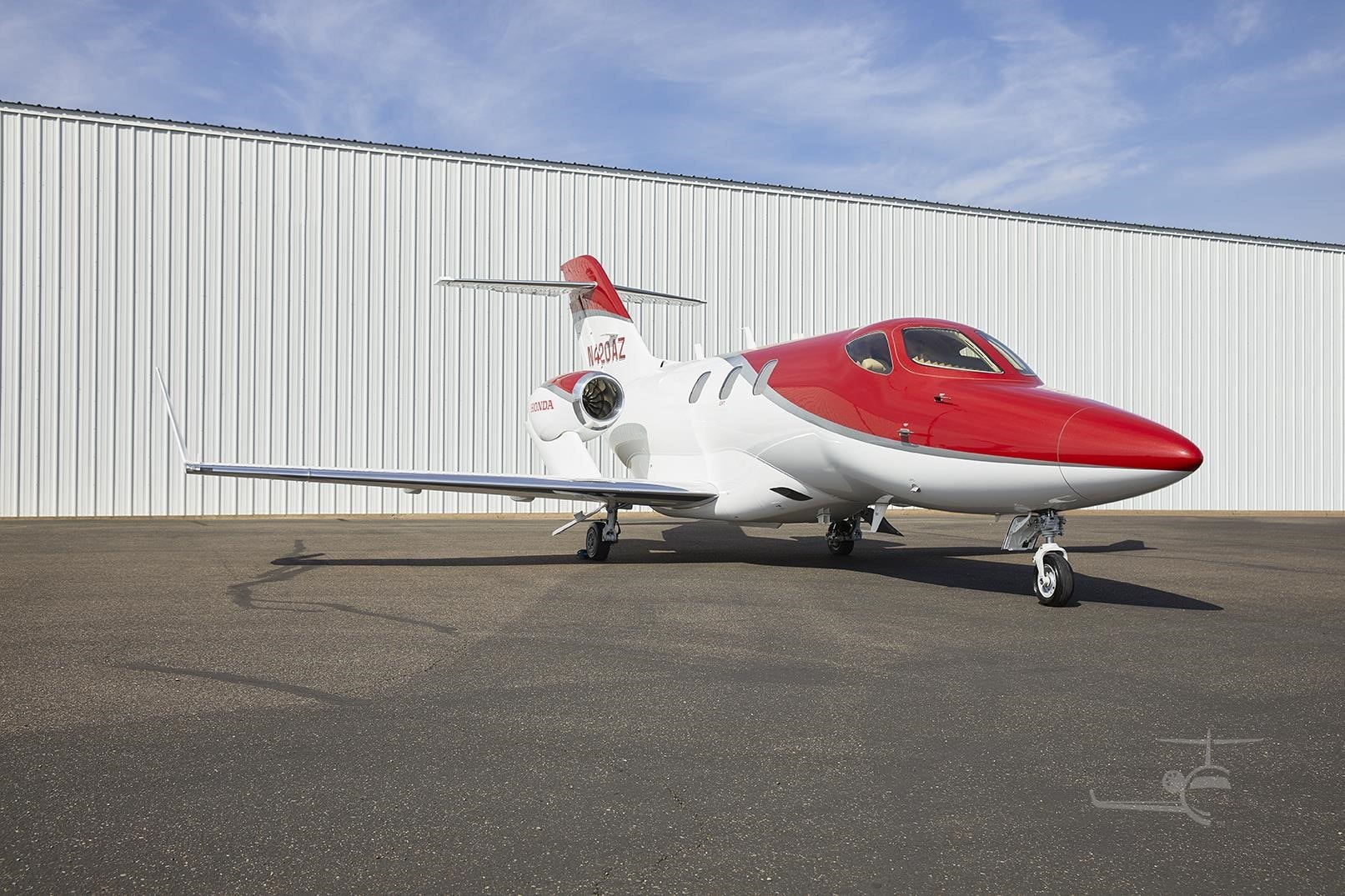 Red and white 2016 HondaJet N420AZ on the airport apron